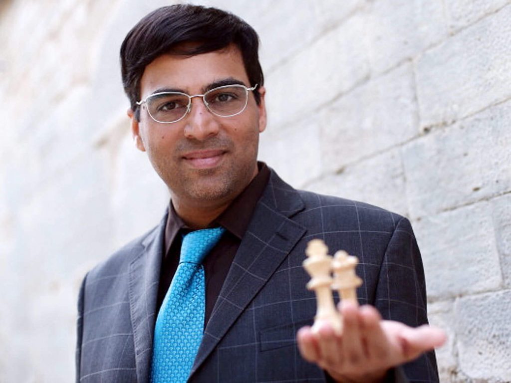 viswanathan anand holding two chess pieces